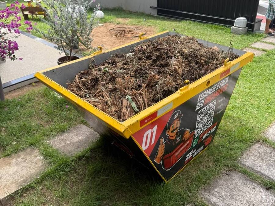 Mini caçamba cheia de restos de poda em jardim residencial